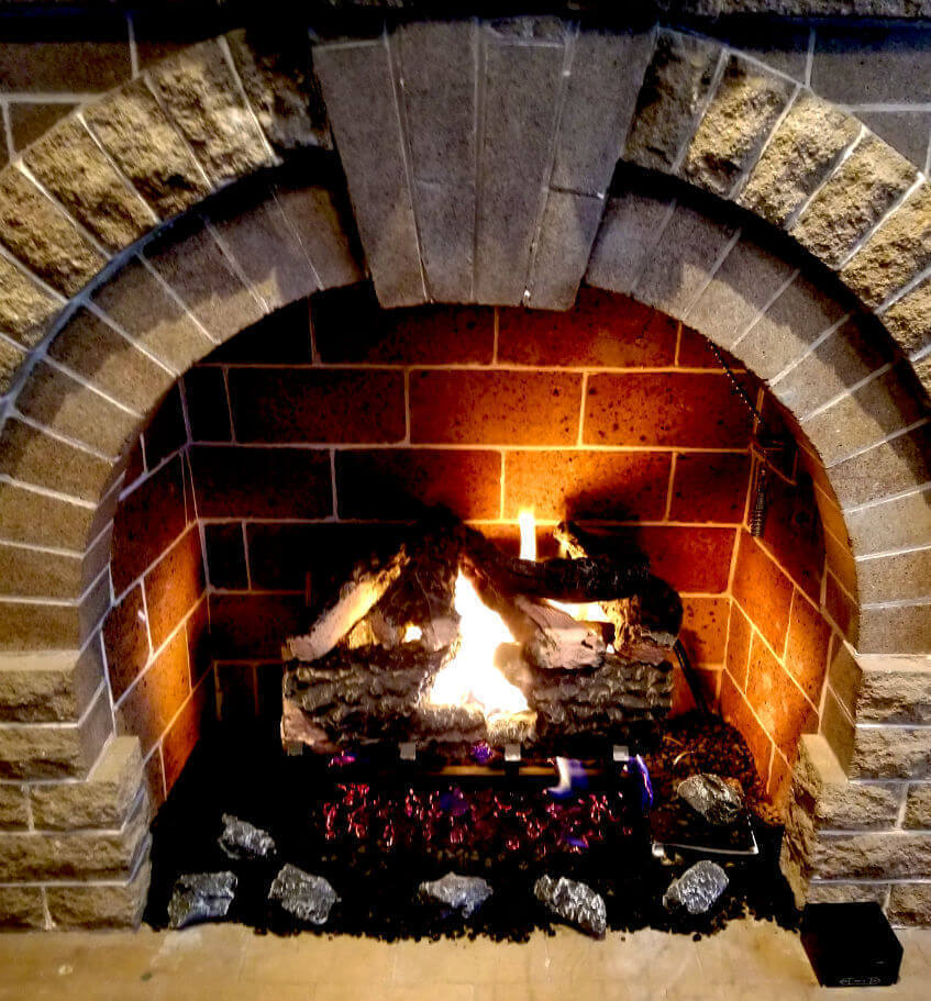 Gas logs set In beautiful arched stone fireplace