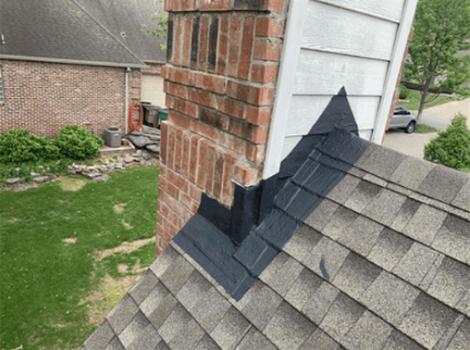Black flashing repair at base of chimney at peak of roof