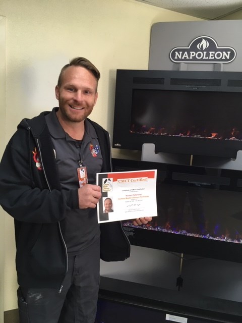 Richard the owner standing in front of Napoleon insert holding a CMCT Certified certificate