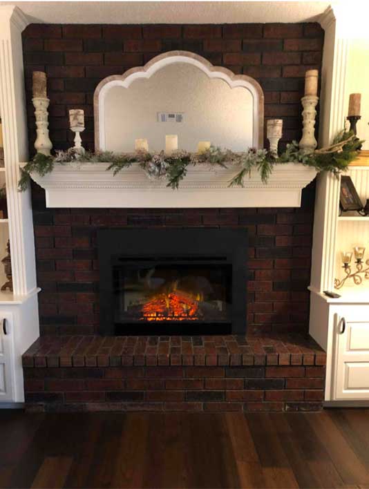 Fireplace before electric upgrade - with insert and beautiful arched mirror above mantel