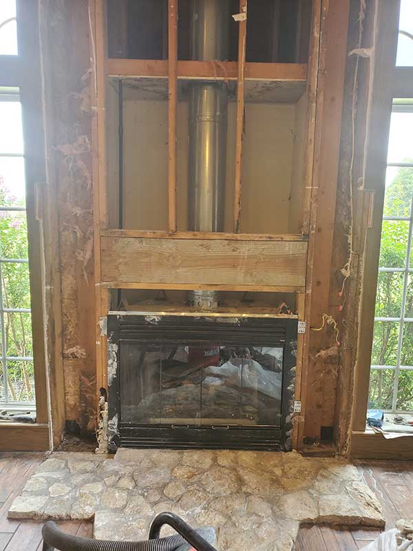 Fireplace Upgrade and Install during construction with river rock rounded hearth and arched windows on each side