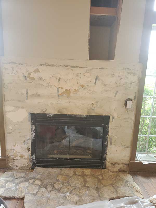 Beautiful completed fireplace with river rock and insert - arched windows on each side