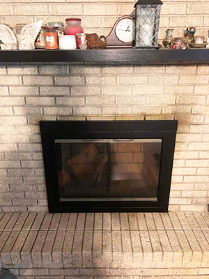 Fireplace after insert installation with white brick surround and mantel fully decorated
