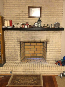 Fireplace before upgrade with no insert and white brick surround