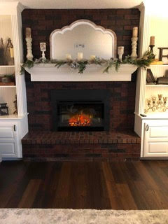Beautiful Electric Fireplace with brick surround and arched mirror on top of mantel
