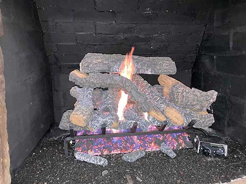 After gas logs are installed with a fire and controls on the front