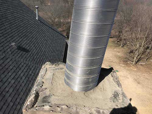 Chimney during relining - long stainless steel liner sticking out of the top